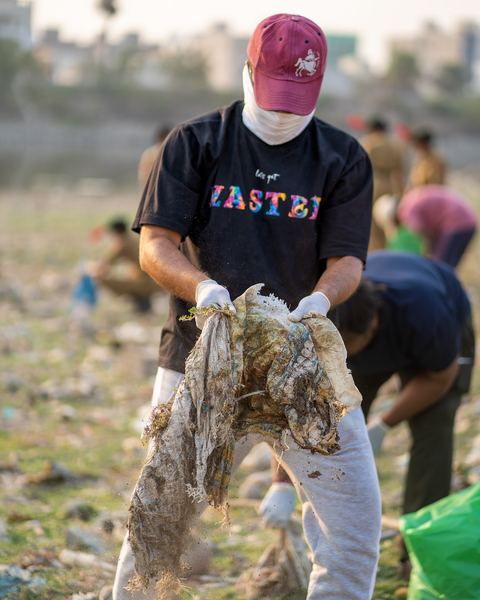 A volunteer pulling waste cloth out of the lakebed