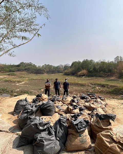 Bags of collected trash lined up by the lake