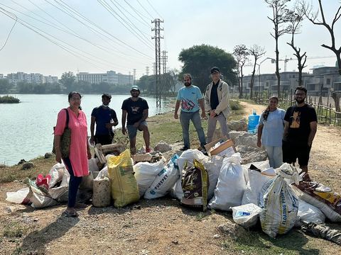 Volunteers with collected bags by the lake
