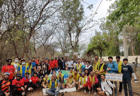 A big group of volunteers and cyclists with the litter they collected